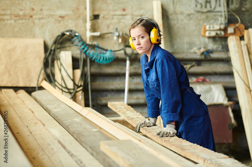 Portrait of female worker sorting wood at production factory, copy space