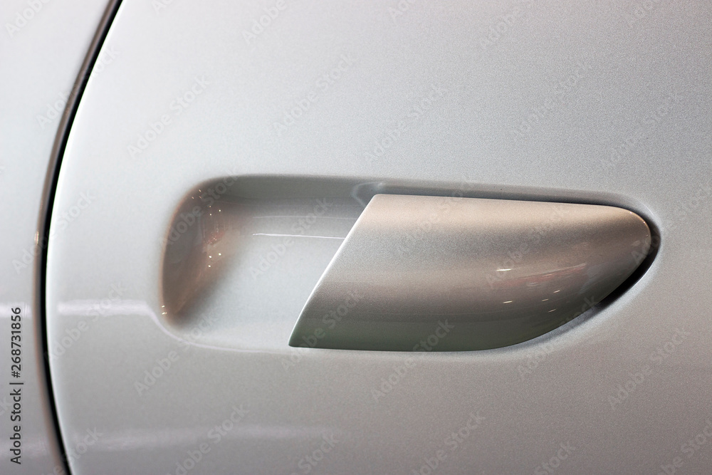 The handle on the car door silver color close up