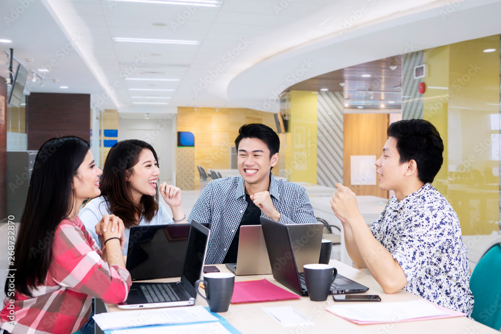 Happy young freelancers have discussion in office