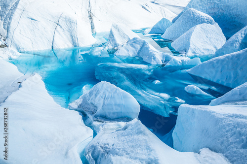 Lake on top of the Matanuska Glacier in Alaska. The deep blue water has flooded an old ice cave or moulin on the surface.
