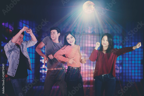 Young Asian people dancing in the nightclub