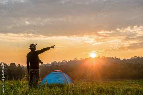 traveller having camping with tent on grass field in morning of sunrise