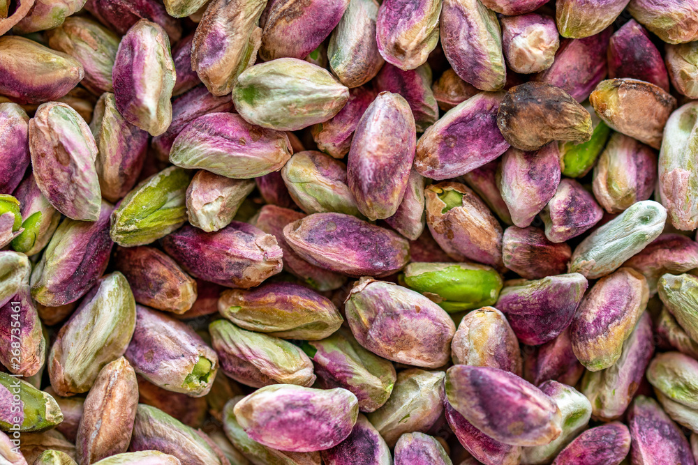 Close-up macro shot of roasted and shelled Australian pistachio nuts. These seeds have a mauve-colored skin and light green flesh and are widely considered to have positive health effects on humans. Close-up macro shot of roasted and shelled Australian pistachio nuts. These seeds have a mauve-colored skin and light green flesh and are widely considered to have positive health effects on humans.