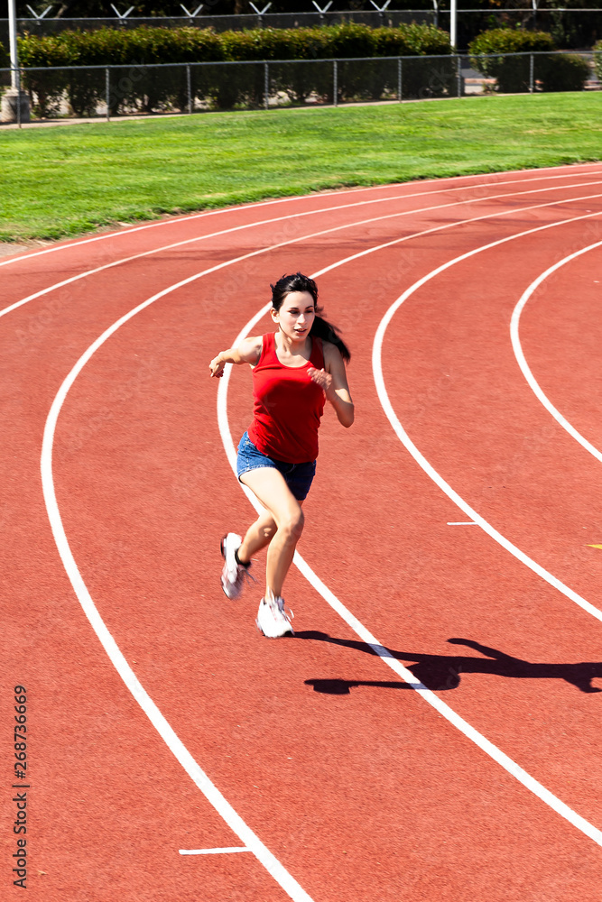 Teen Hispanic Woman Running On Track Shorts And Top Teen Hispanic Woman Running On Track Shorts And Top