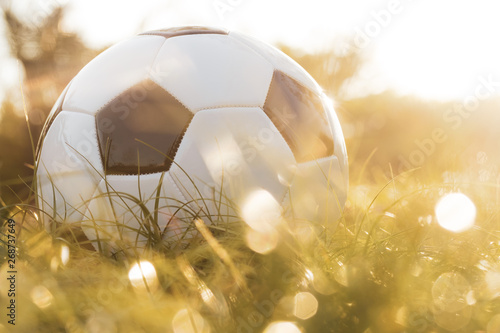 football on grass with bokeh and golden sunlight background