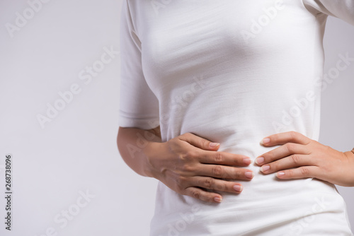 Young woman having painful stomachache. Chronic gastritis. Abdomen bloating and healthcare concept.