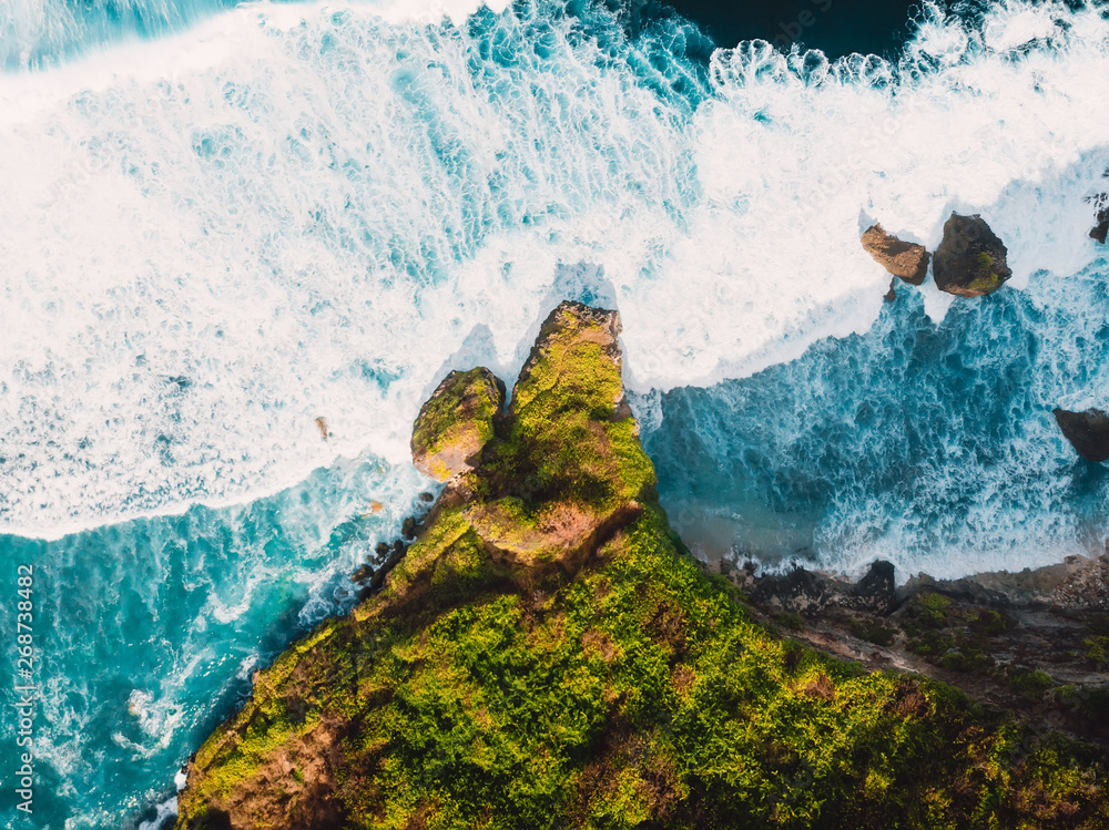 Aerial view with rocks and ocean with big waves in Bali
