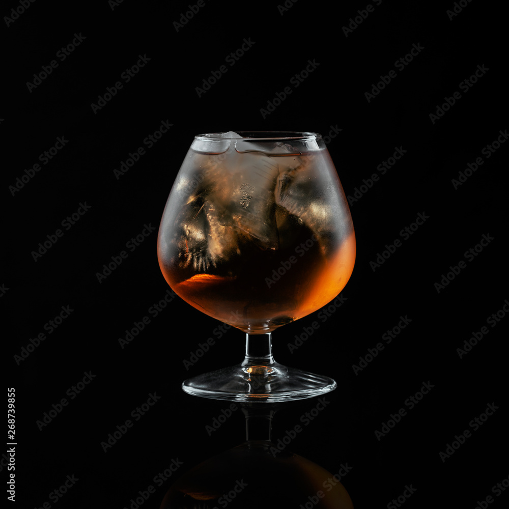 Close-up brandy glass filled with whiskey with ice. Close-up brandy glass filled with whiskey with ice.