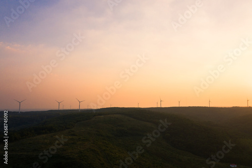 The windmills on the top of a mountain. They generate green energy from the nature.