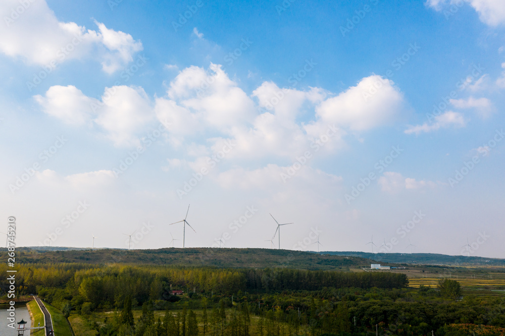 Fototapeta premium The windmills on the top of a mountain. They generate green energy from the nature.