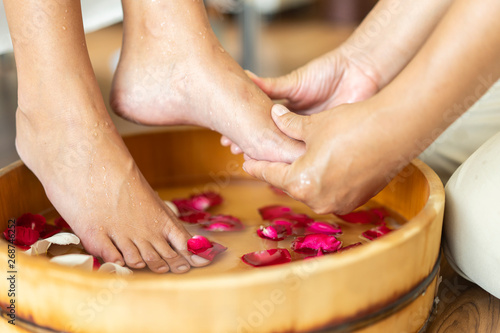 foot massage - feet of woman or customer at spa pedicure procedure and having feet massage in beauty salon. beauty ,woman and lifestyle concept