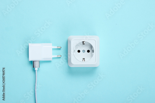Charger and power outlet on blue background