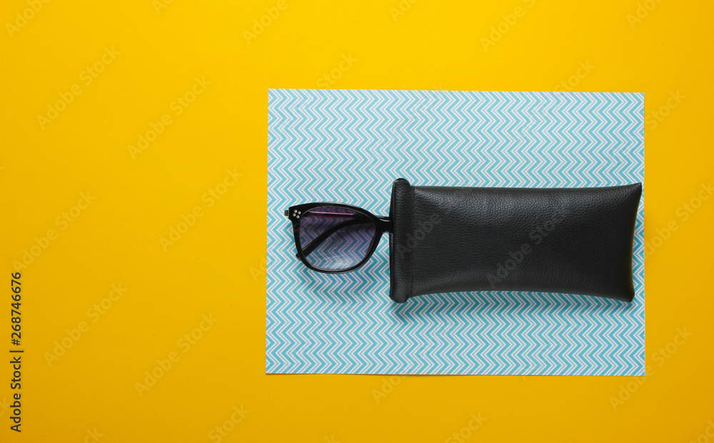 Fashionable sunglasses in a protective case on a cardboard background. Top view Fashionable sunglasses in a protective case on a cardboard background. Top view