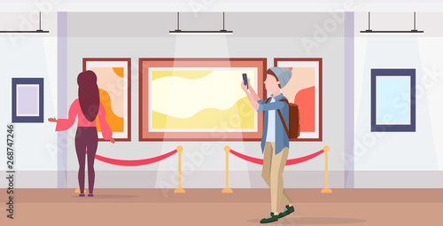 man art gallery visitor taking selfie photo on smartphone camera casual male cartoon character in hat with backpack posing modern museum interior flat full length horizontal