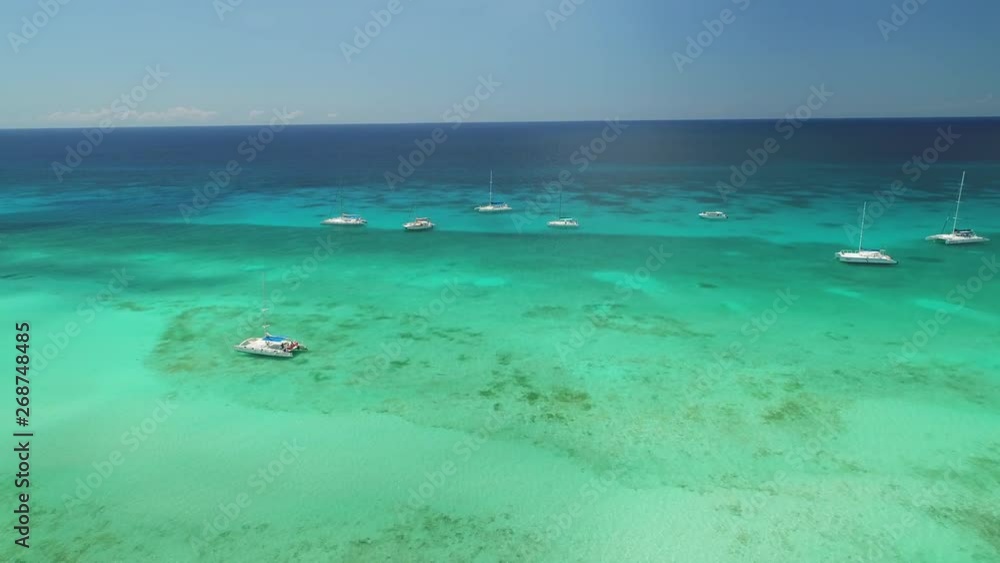 Aerial view over Caribbean sea water. Catamaran, sailboats and speed boats in the ocean. Aerial view over Caribbean sea water. Catamaran, sailboats and speed boats in the ocean.