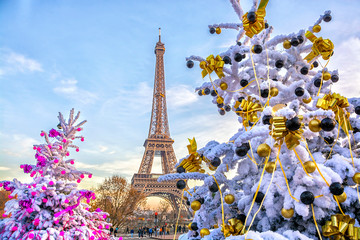 Eiffel Tower is the main attraction of Paris on the background of decorated Christmas trees in December. Travel Greeting Card with Christmas in Paris, France