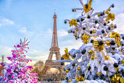 Eiffel Tower is the main attraction of Paris on the background of decorated Christmas trees in December. Travel Greeting Card with Christmas in Paris, France