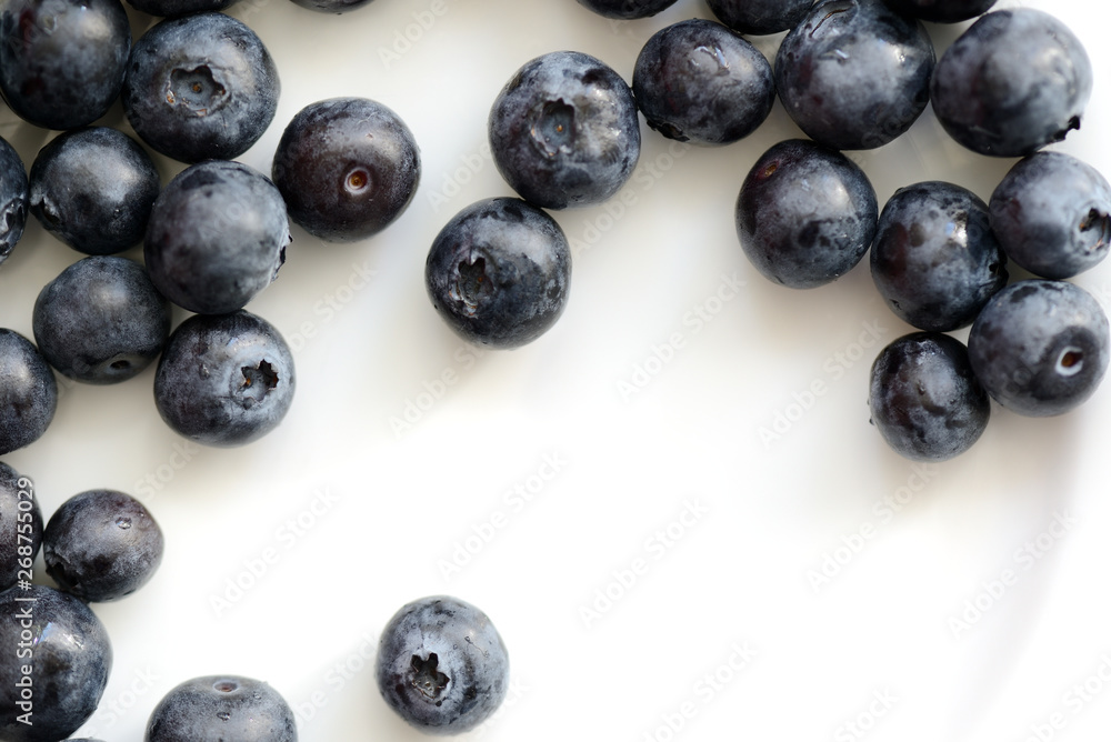 Fresh blueberry berries on a white plate close up. Top view Fresh blueberry berries on a white plate close up. Top view