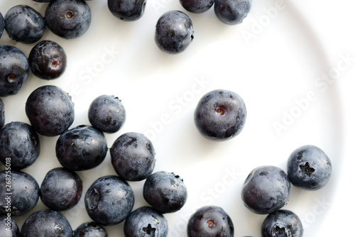 Fresh blueberry berries on a white plate close up. Top view