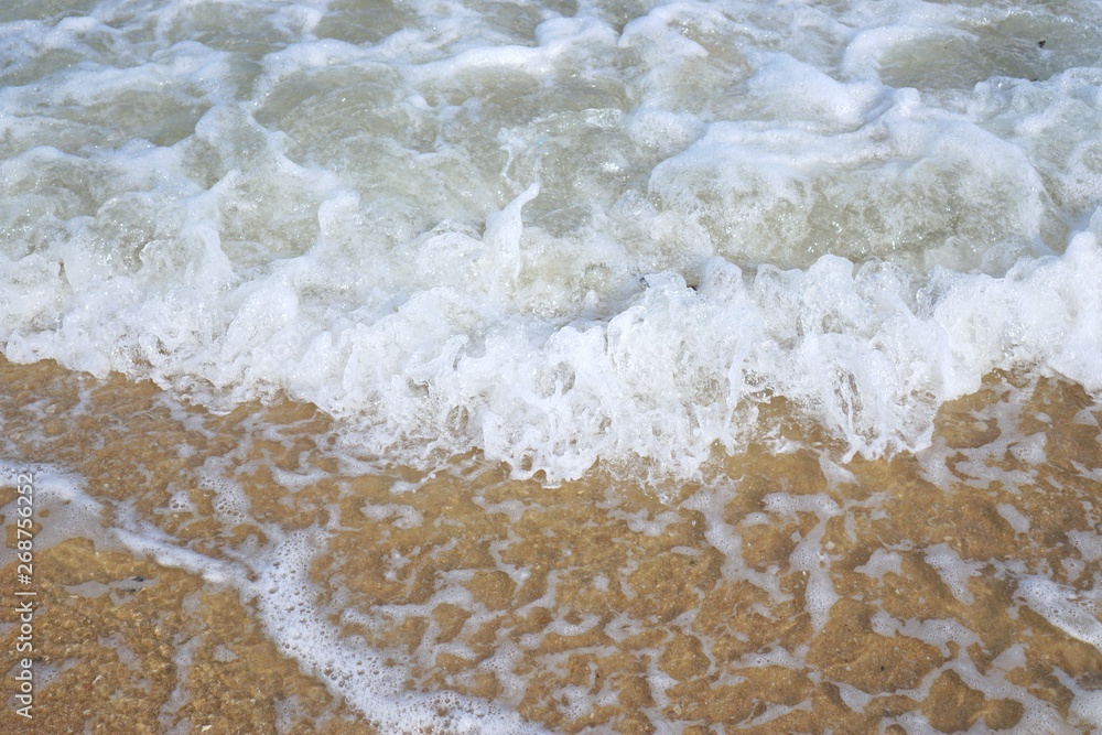 Soft wave of the sea on the sandy beach in the morning, Sea with little wave at Cha am, Thailand. Abstract background, Space for text in template Soft wave of the sea on the sandy beach in the morning, Sea with little wave at Cha am, Thailand. Abstract background, Space for text in template