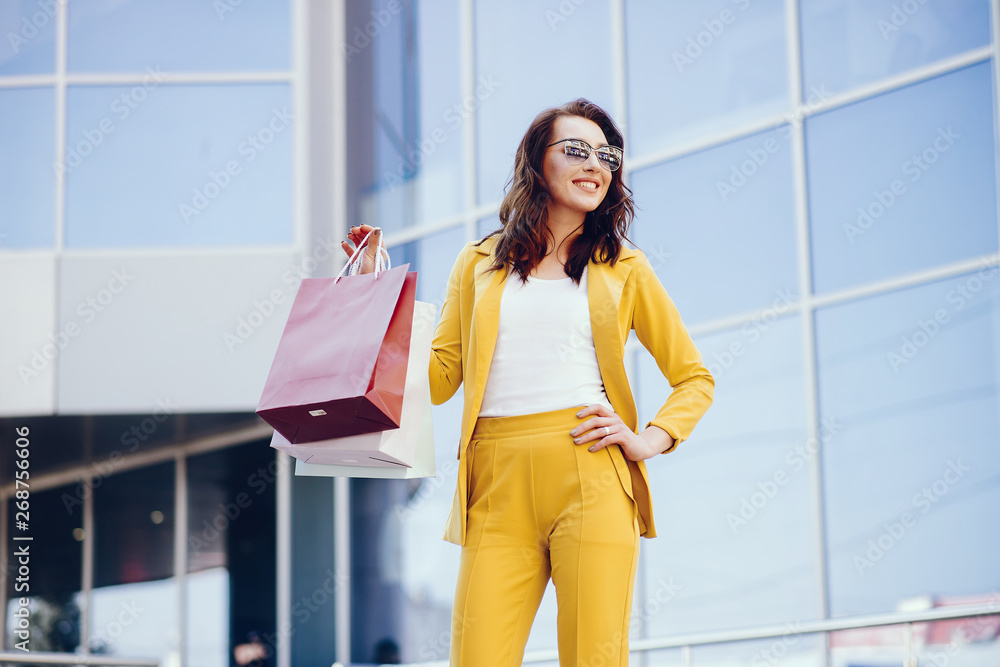 Beautiful girl in a summer city. Lady with shopping bags