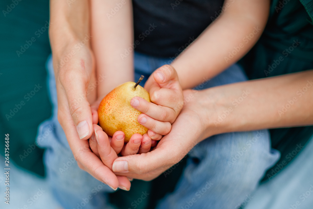 woman and child holding a pear woman and child holding a pear