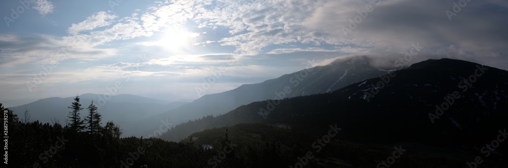 Babia Gora - mountain range in Beskid Zywiecki during spring with fog, clouds and sun