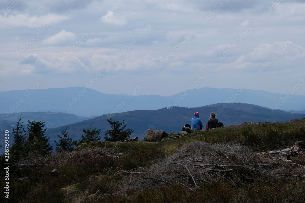Beskid Zywiecki during spring - sitting tourists are waching view from hill Cyl Hali Smietanowej near Zawoja