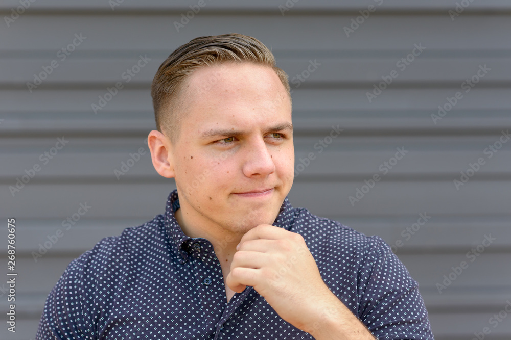 Naklejka premium Thoughtful young man with his hand to his chin