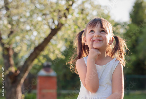 Bilde på lerret Happy little girl dreaming in the garden.