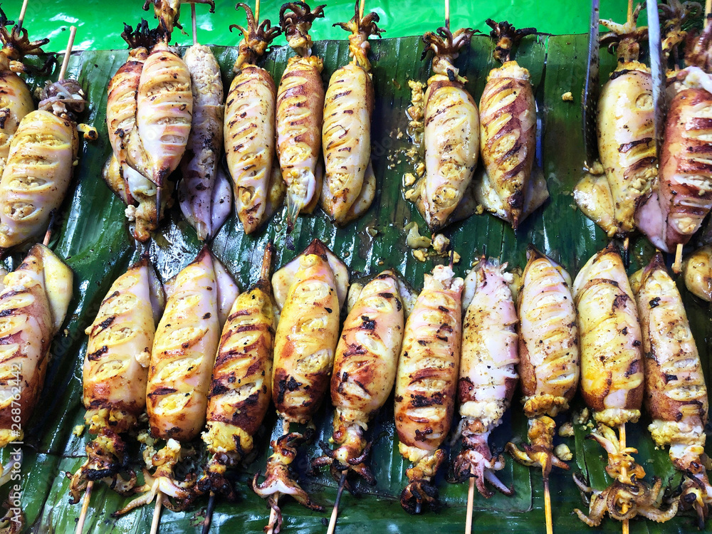 Charcoal grilled stuffed Squid Calamari cattle fish on green banana leaf Charcoal grilled stuffed Squid Calamari cattle fish on green banana leaf