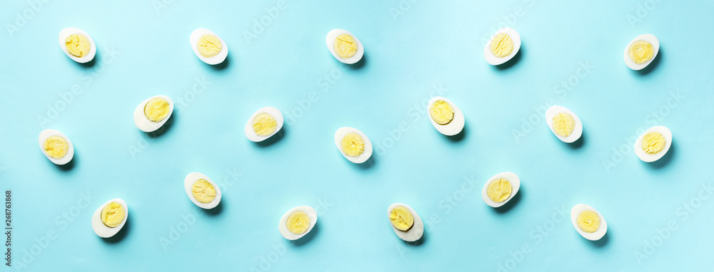 Food concept with boiled eggs pattern on blue background. Top view. Creative pattern in minimal style. Flat lay. Banner