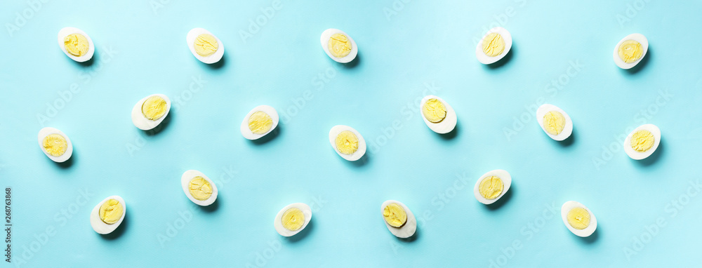 Food concept with boiled eggs pattern on blue background. Top view. Creative pattern in minimal style. Flat lay. Banner Food concept with boiled eggs pattern on blue background. Top view. Creative pattern in minimal style. Flat lay. Banner