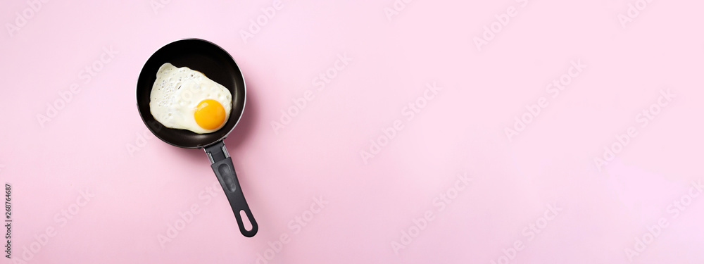 Creative food concept with fried egg on pan over pink background. Top view. Creative pattern in minimal style. Flat lay. Banner - obrazy, fototapety, plakaty 