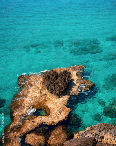 Beautiful turquoise clean water and blue sky in famous touristic Ayia Napa, Paralimni, Cyprus on a sunny day with amazing rock formations and cliffs.