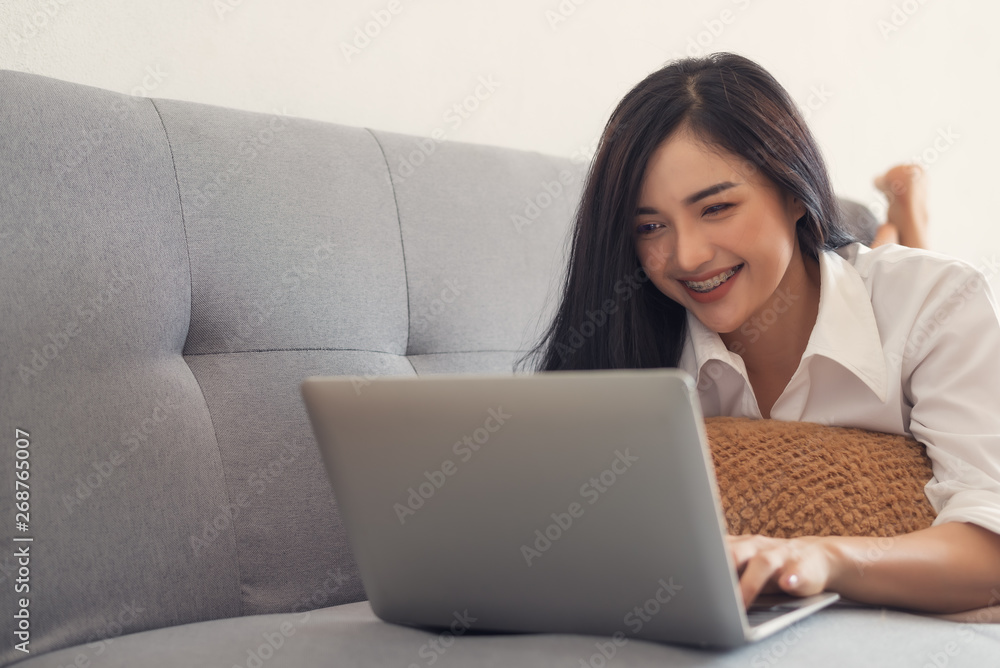 Beautiful young Asian girl working in living room at home with laptop,working woman concept. Beautiful young Asian girl working in living room at home with laptop,working woman concept.