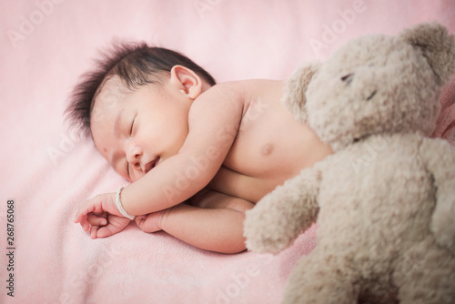 Asian Newborn baby sleeping on blanket