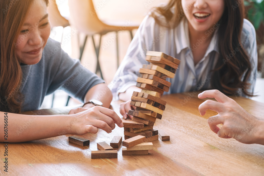 Valokuva Three asian friends sitting and playing Tumble tower wooden block game together