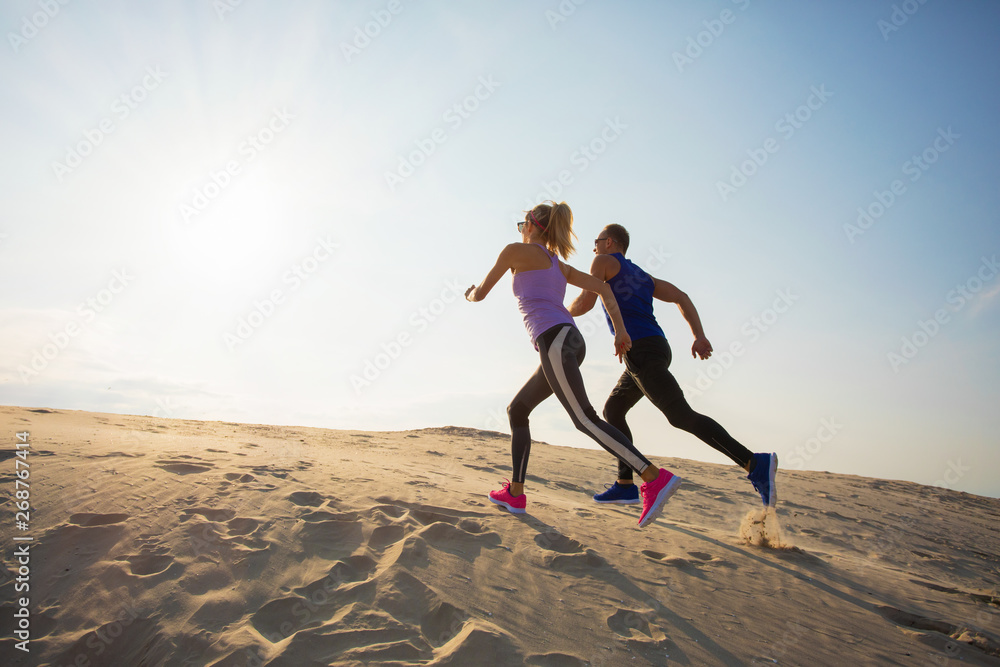 Energetic couple running uphill Energetic couple running uphill