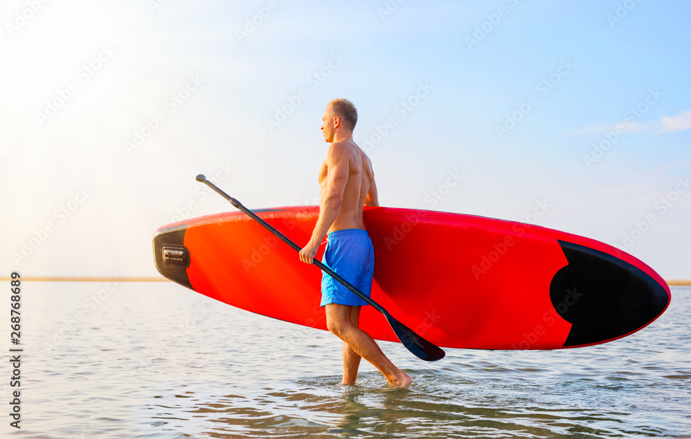 Man walking in the water with SUP board