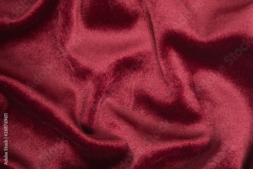 Red velvet background with waves on it. Abstract textile decoration