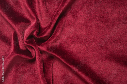 Red velvet background. Abstract textile texture with waves. Copy space. Flat lay