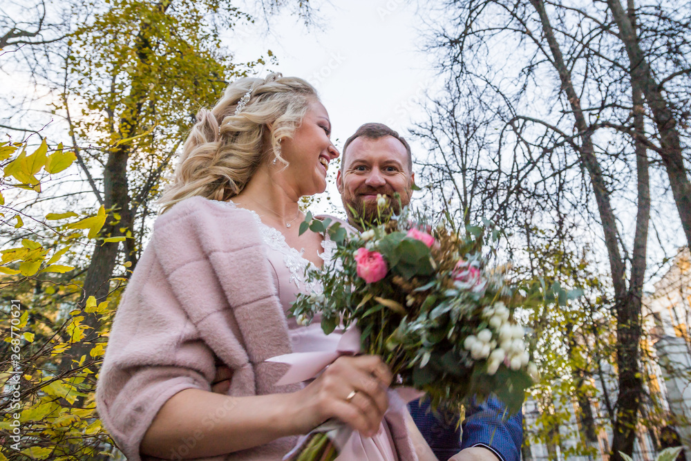 International bride and groom together in green city park International bride and groom together in green city park