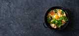 Healthy breakfast table with fry pan eggs with spinach and corn on dark stone background top view