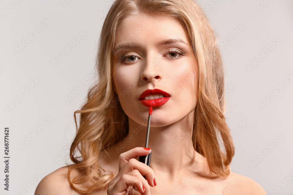 Beautiful young woman with bright lipstick on light background Beautiful young woman with bright lipstick on light background