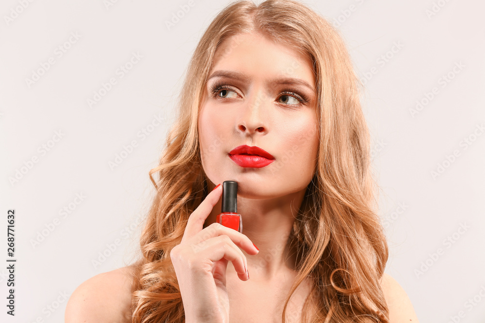 Beautiful young woman with bright nail polish on light background Beautiful young woman with bright nail polish on light background