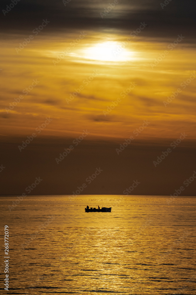 Fishermen in the sea during beautiful sunrise. 