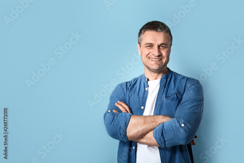 Portrait of handsome mature man on color background photo