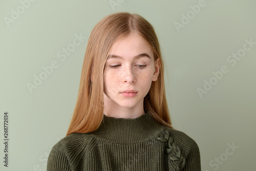 Sad teenage girl on color b...
