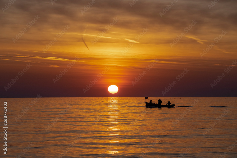 Fishermen in the sea during beautiful sunrise. 